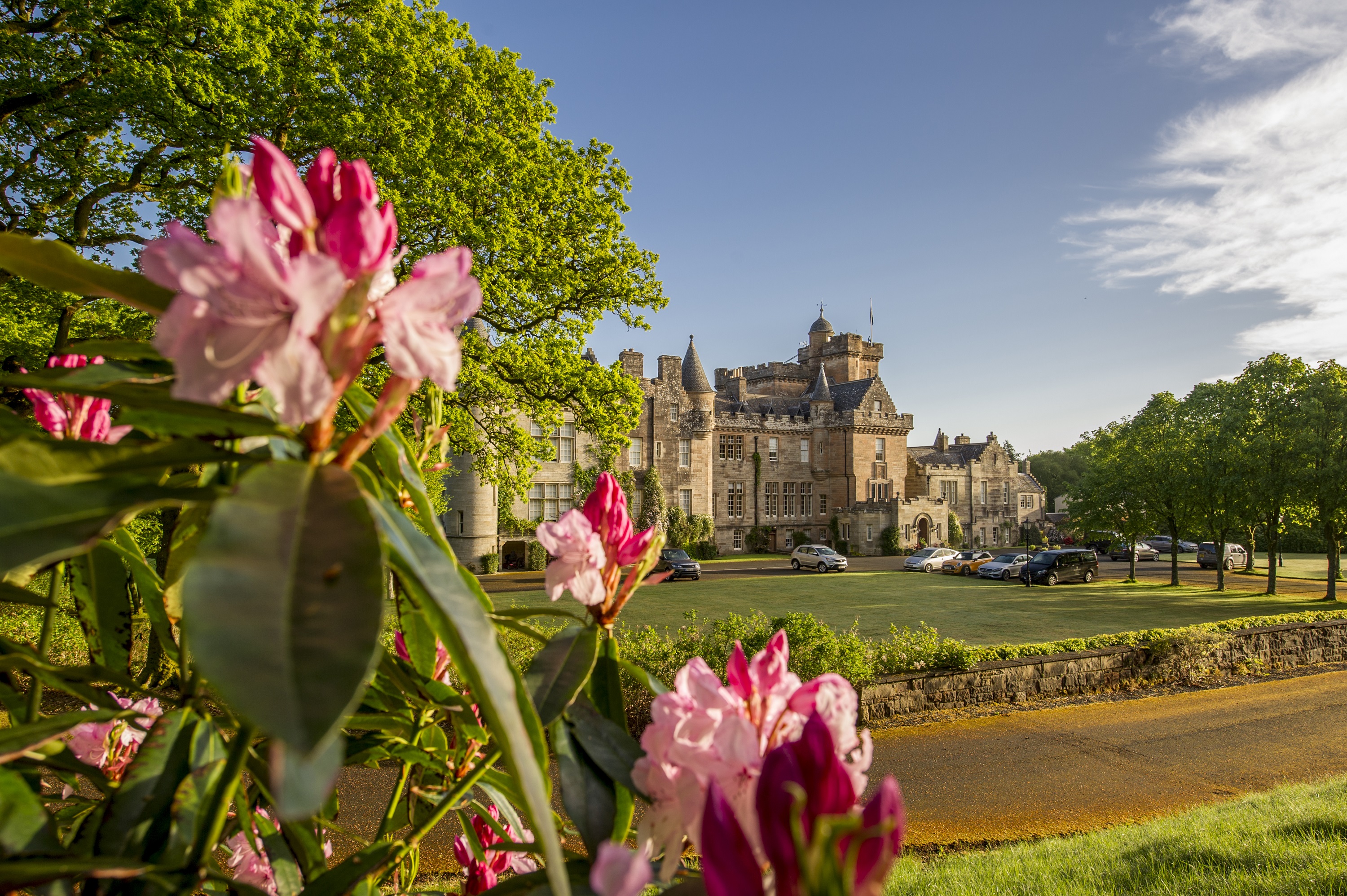 View through the flowers over the lawn of the exterior of Glenapp Castle in the Scottish Lowlands